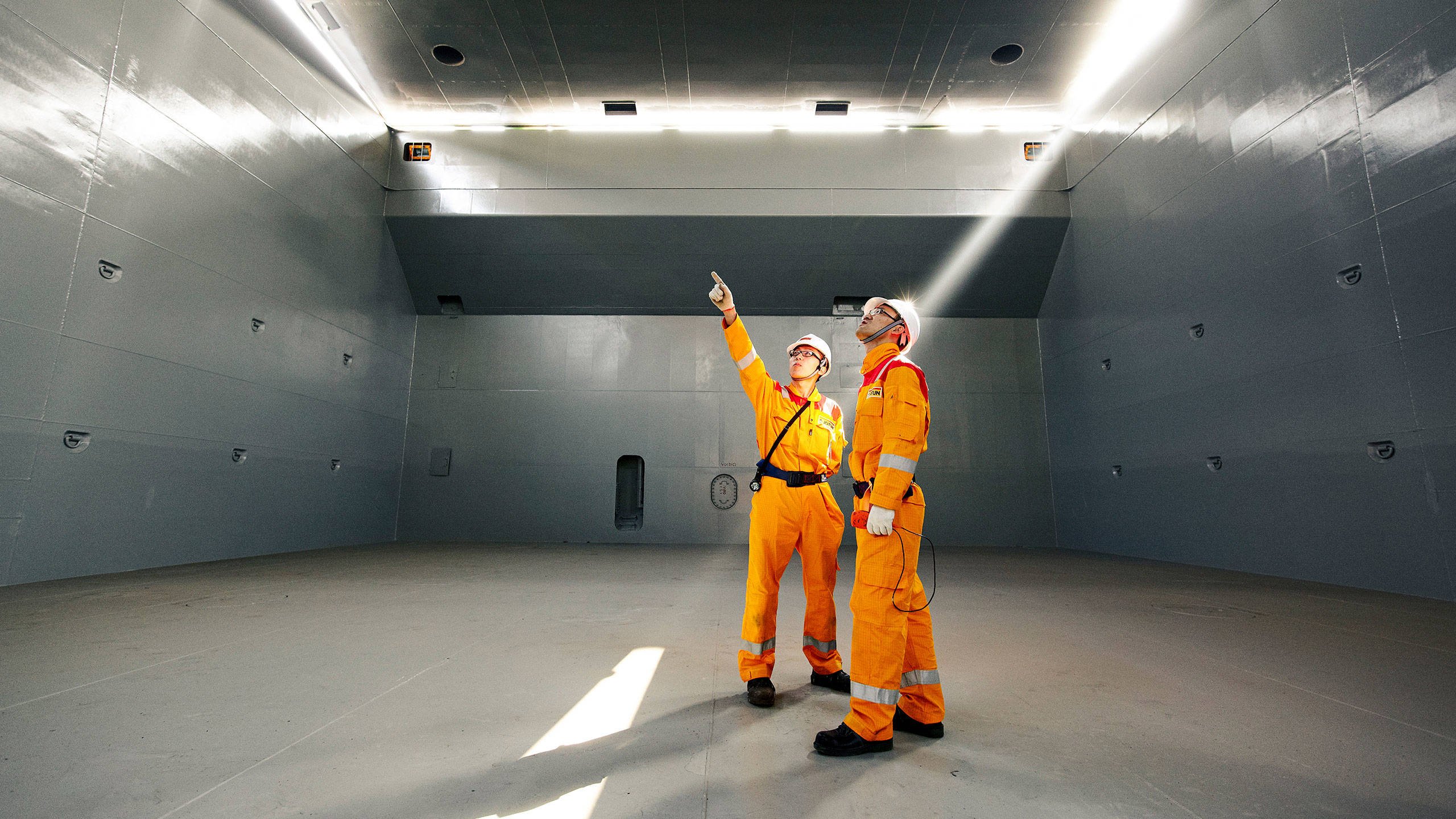 Two members of Jotun's Technical Service team inside a ship hull