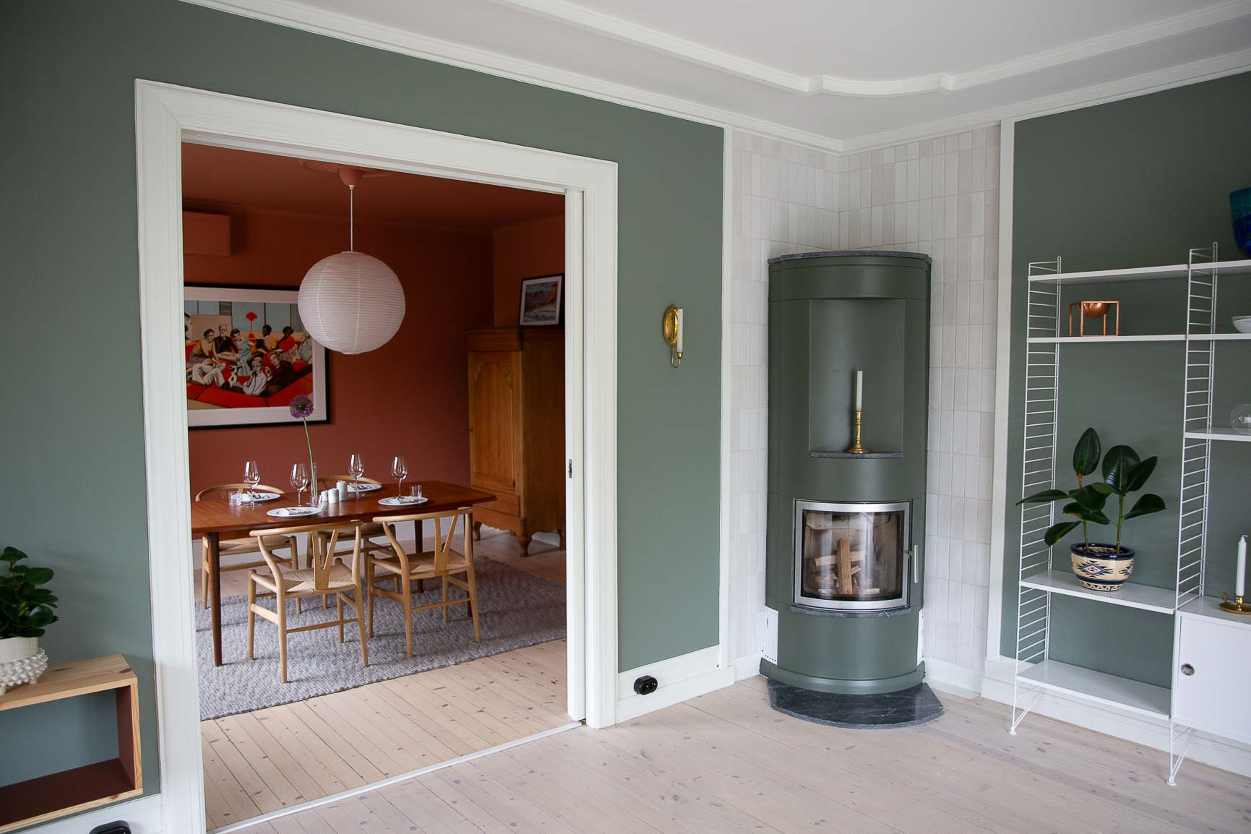 Stue med grønnmalte vegger i Jotun Treasure, og peis malt med mørkere grønne Northern Mystic.