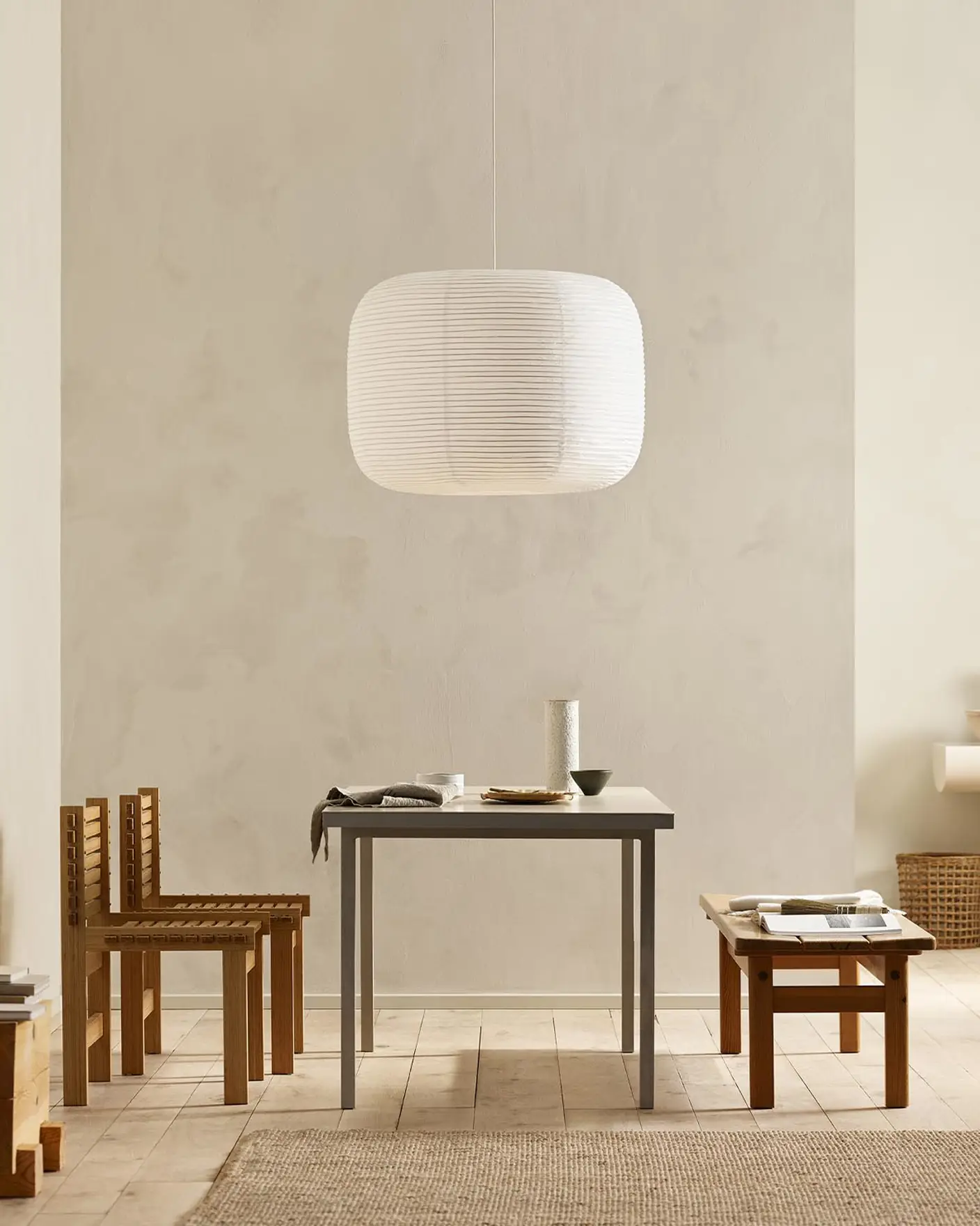 Minimalist dining area with wooden chairs, pendant light, and golden beige walls painted with the colour 12308 Unbleached from Jotun.
