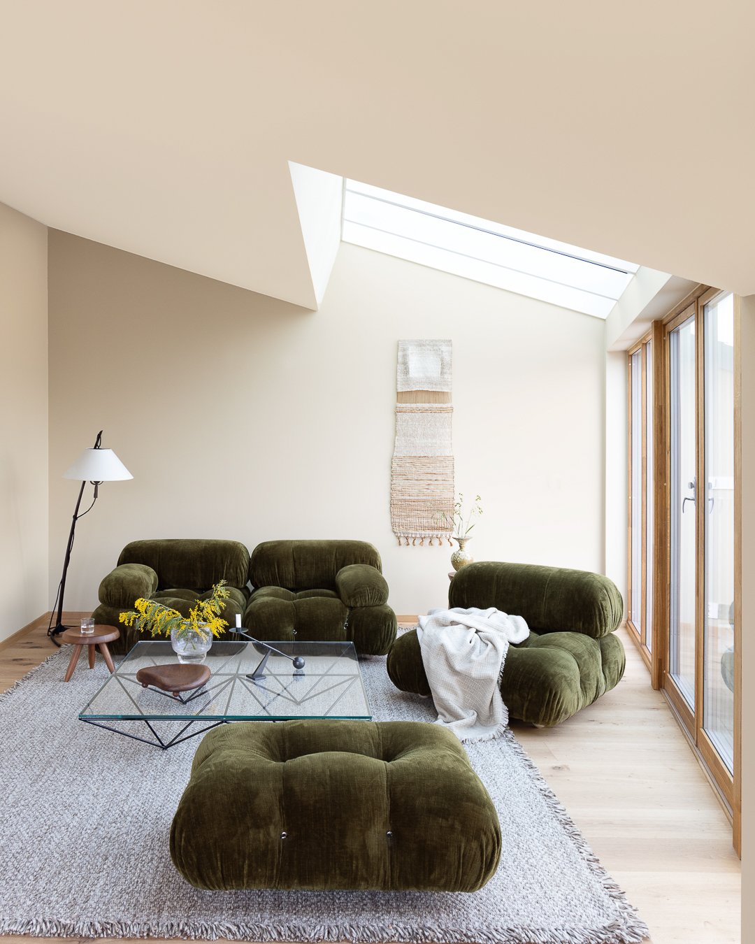 Livingroom with modern furnishing in forest green with beige walls painted in JOTUN 1303 Observe and a lighter beige ceiling painted in JOTUN 12313 Soft Dunes.