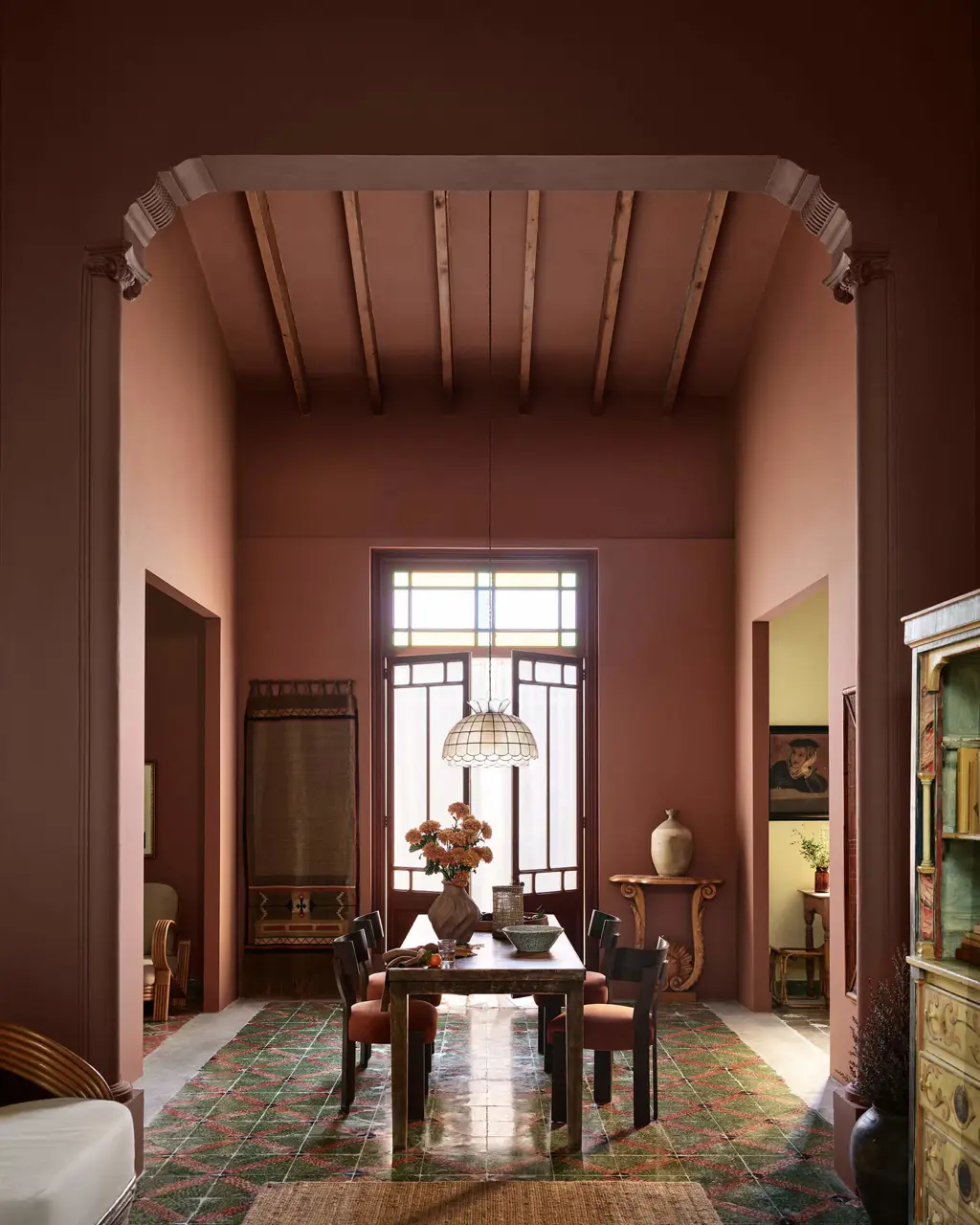 A kitchen dining space with high ceilings and tiled floors painted in Jotun 2993 Kilim, Jotun 20118 Amber Red, and Jotun 1627 Retro