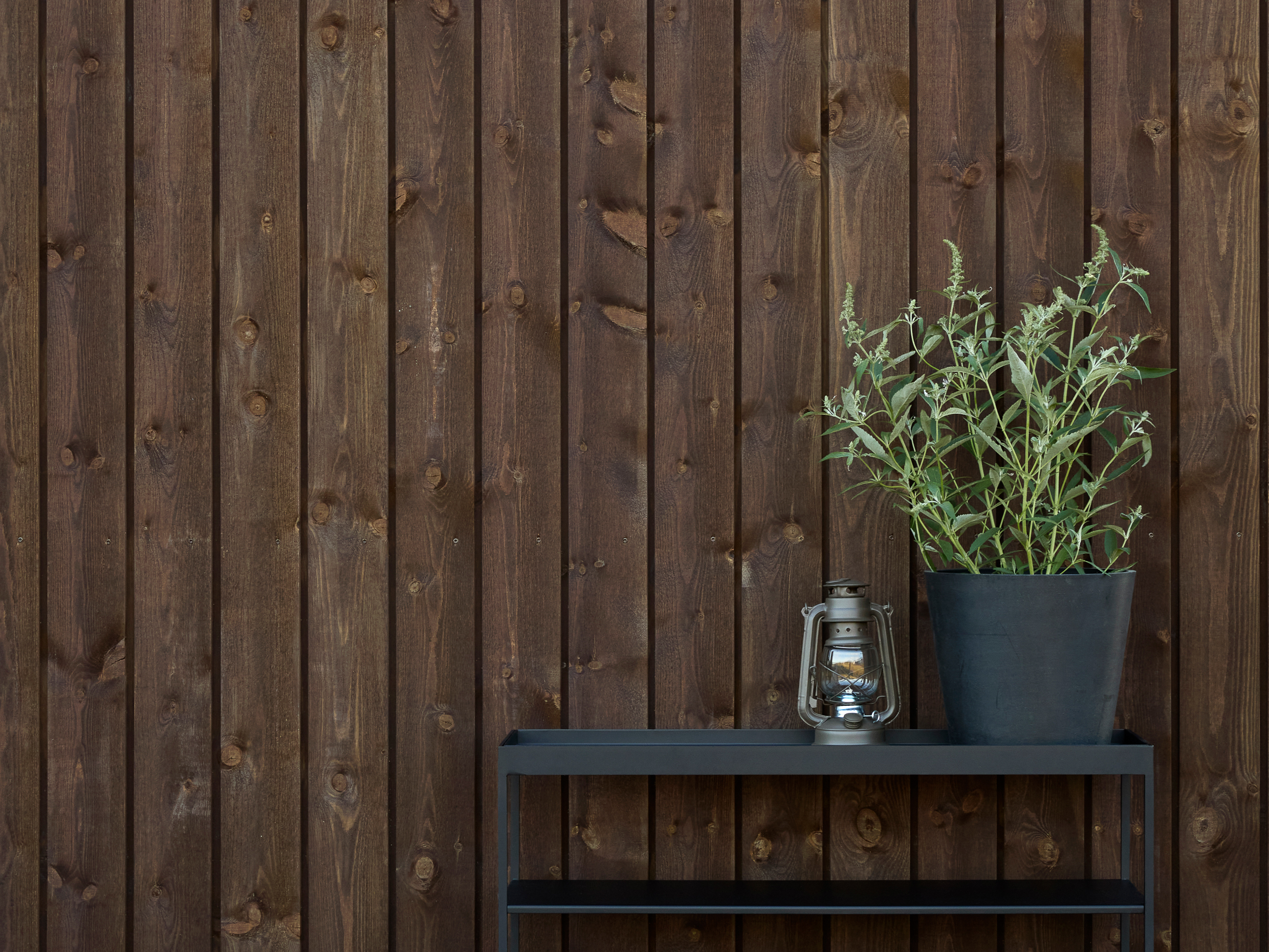 Vegg utendørs med stående panel oljet med TREBITT WoodCare vedlikeholdsolje i den mørkebrune fargen TREBITT 9155 Rich Brown.