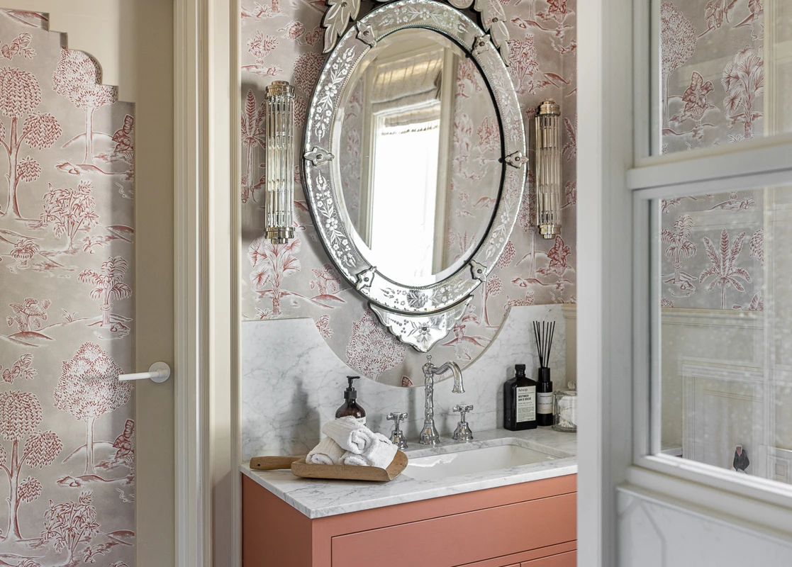 Bad med venetiansk speil, tapet, beige listverk, møbel malt i korallfarge LADY Muted Coral.