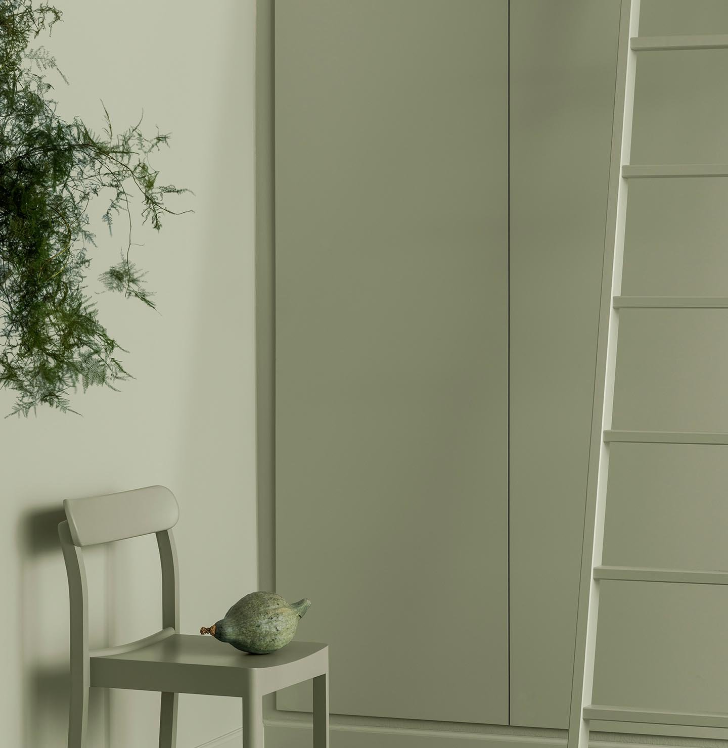 Soft green tones fill this space with a painted chair, ladder and cabinets blending seamlessly, creating a calm, monochrome look with a natural touch. All painted with the colour 7038 Dusk Green from Jotun.