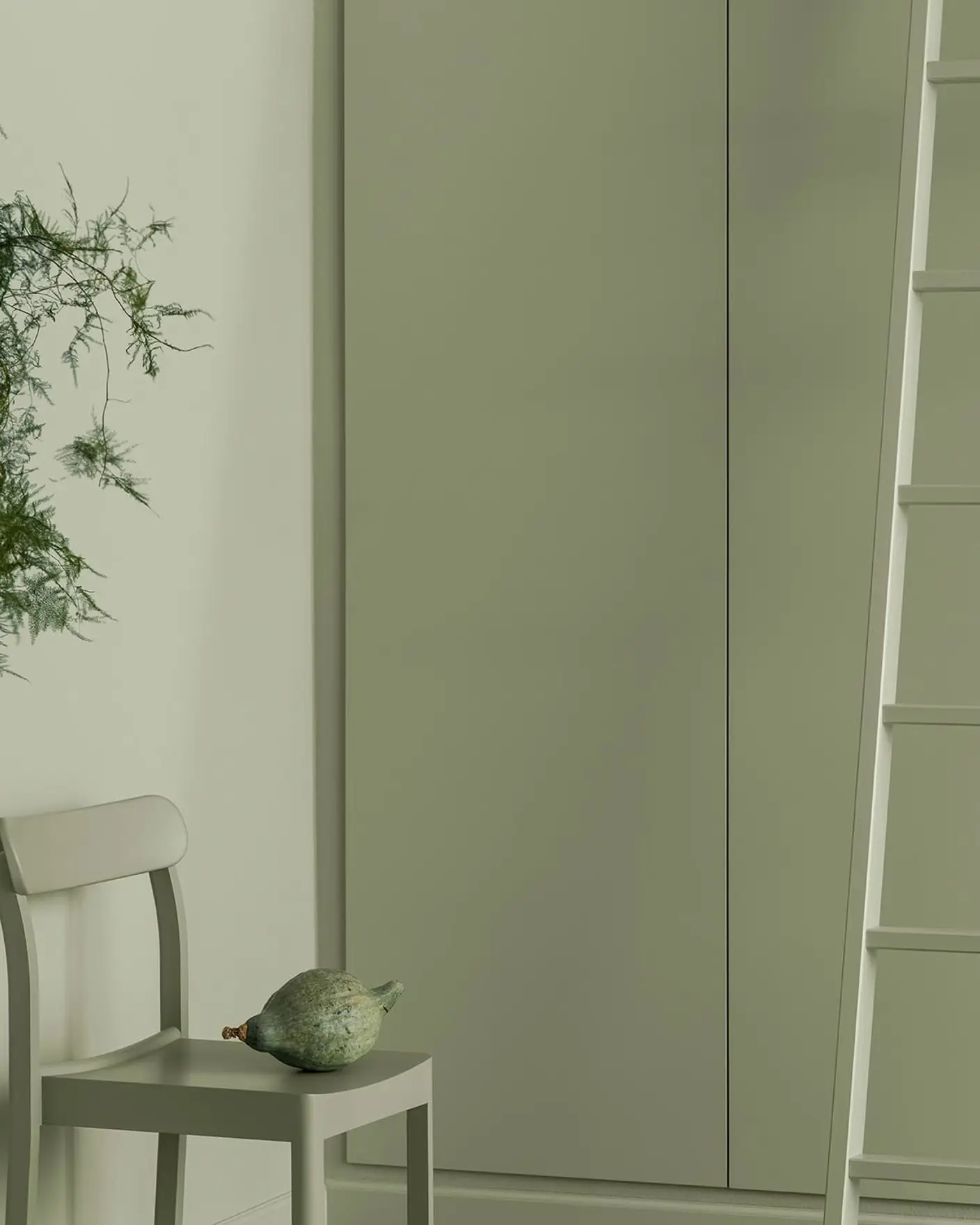 Soft green tones fill this space with a painted chair, ladder and cabinets blending seamlessly, creating a calm, monochrome look with a natural touch. All painted with the colour 7038 Dusk Green from Jotun.
