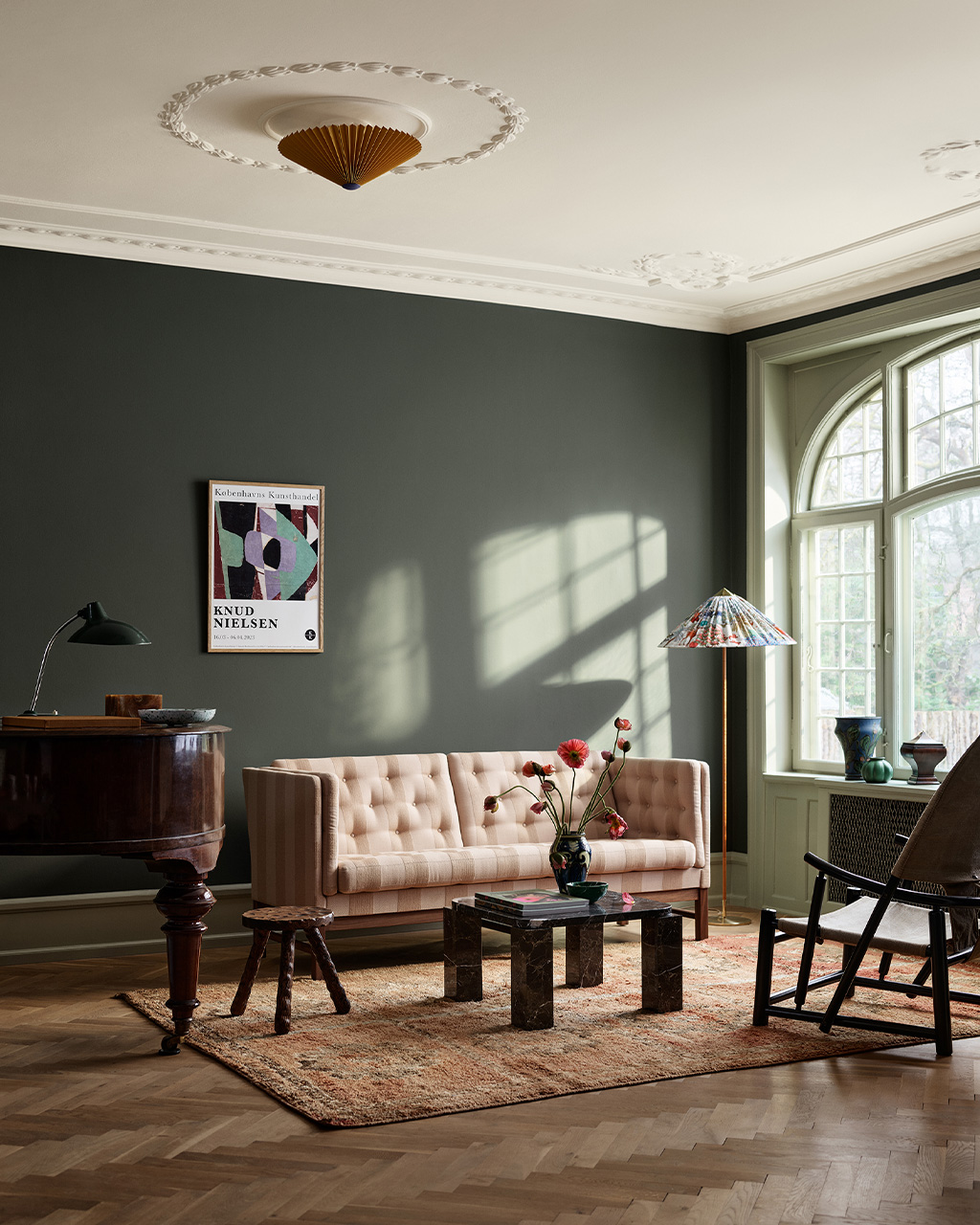 Beige soffa framför en grön vägg i färgen Northern Mystic från Jotun