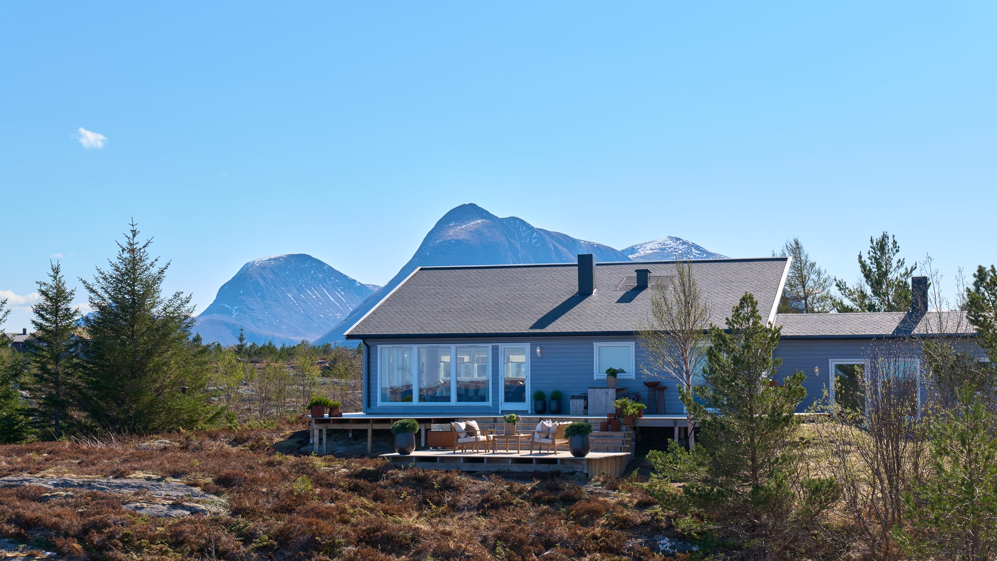 Hytte med fjell bak og høy blå himmel, Eventyrlig Oppussing på Tustna