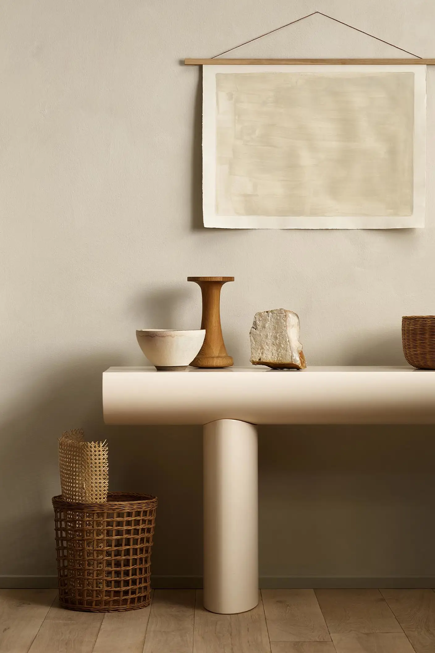 Minimalist console table with decor and baskets against a golden beige wall painted with Jotun's colour 12308 Unbleached.