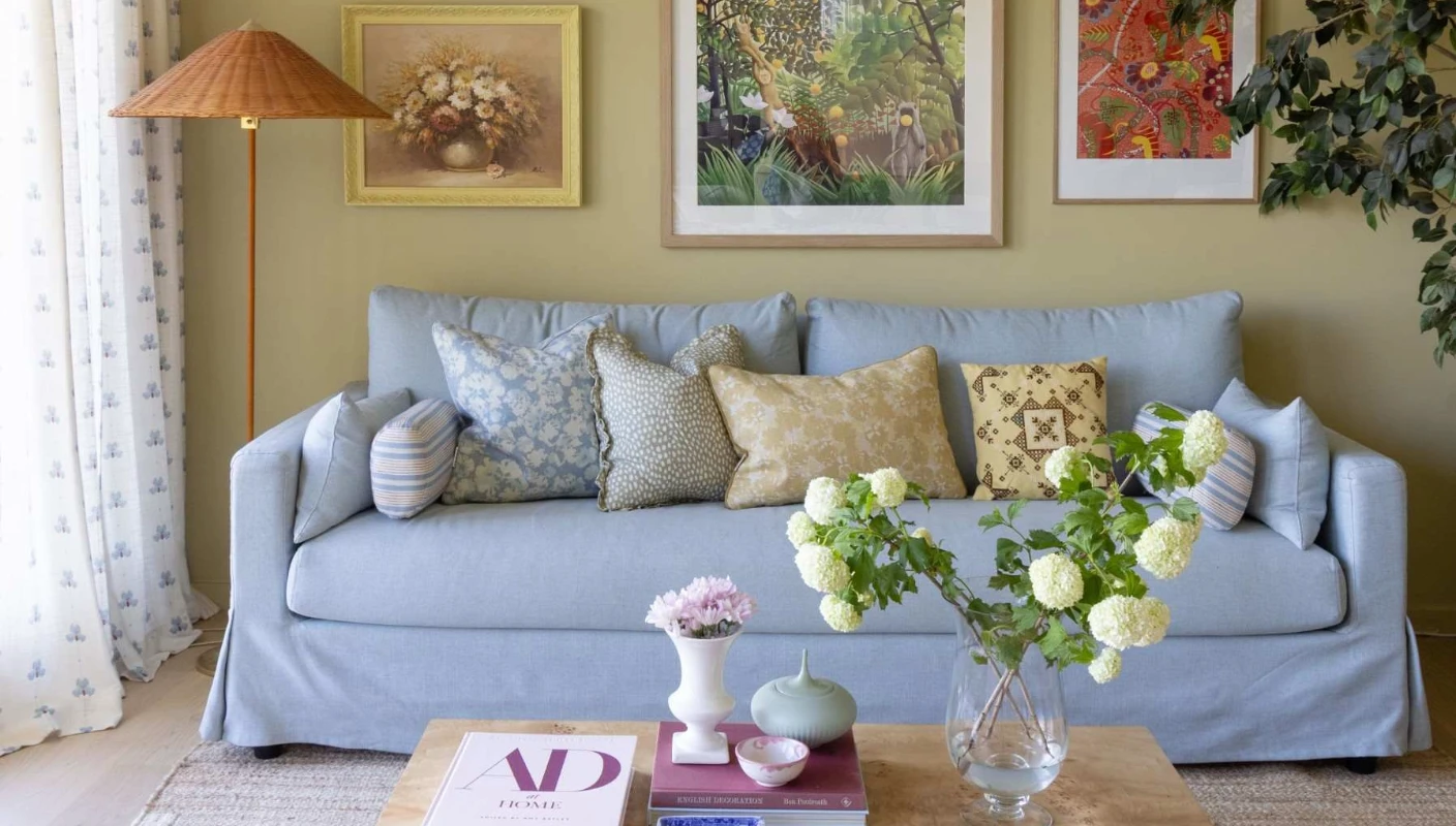 Living room painted in Jotun Earthy Yellow, with a bright blue sofa