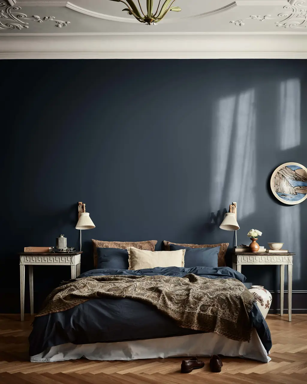Et dramatisk soveværelse med vægge malet i den dybe marineblå nuance Jotun 4403 Midnight Blue, et hvidt, dekorativt loft malet i Jotun 11364 Century White samt symmetrisk placerede natborde.