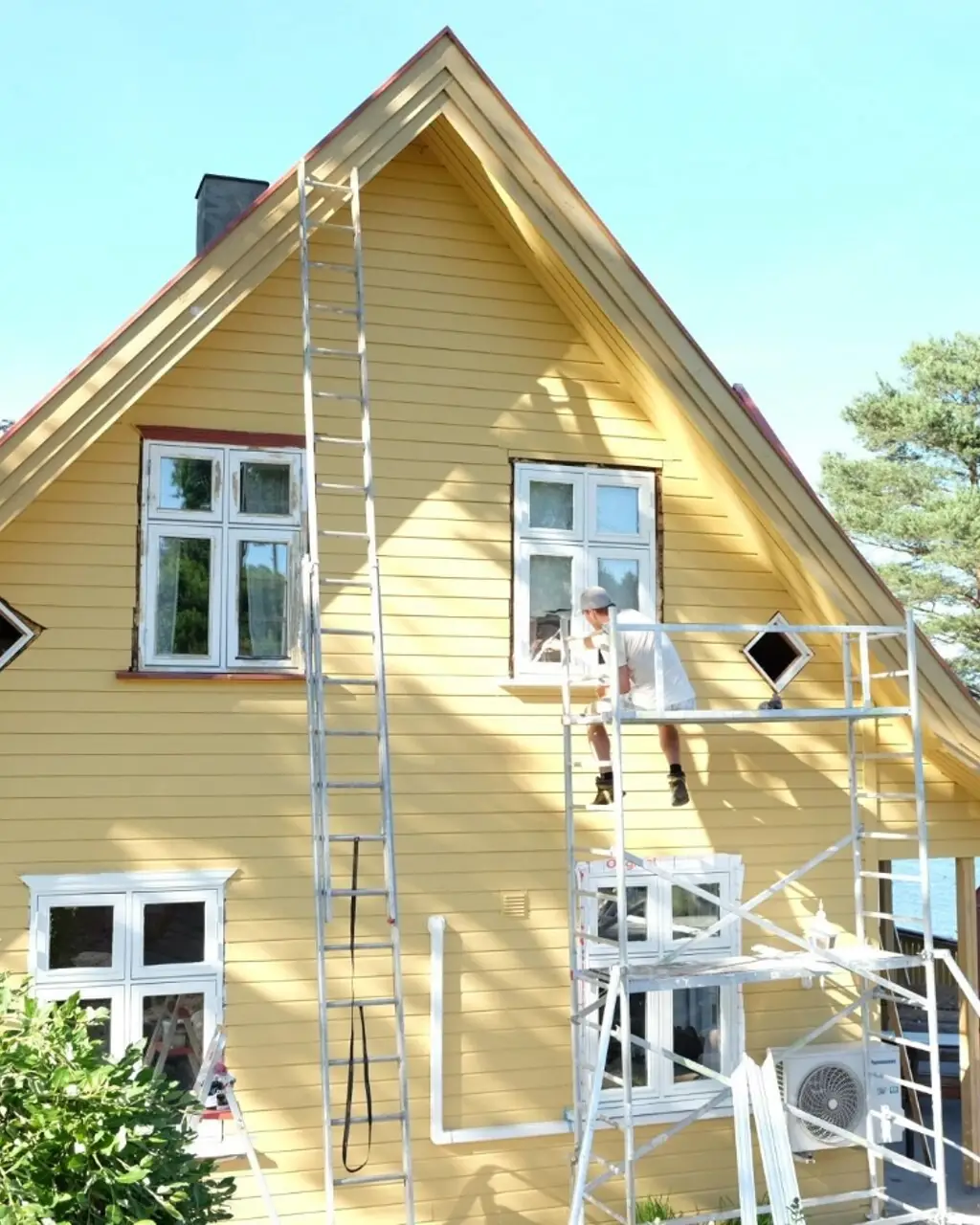 Mann maler klassisk villa i Jotun Skagengul