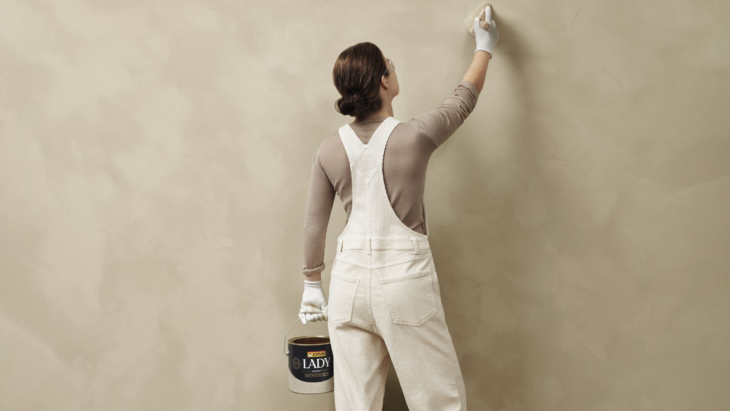 Person viser hvordan man maler en vegg med LADY Minerals Kalkmaling
