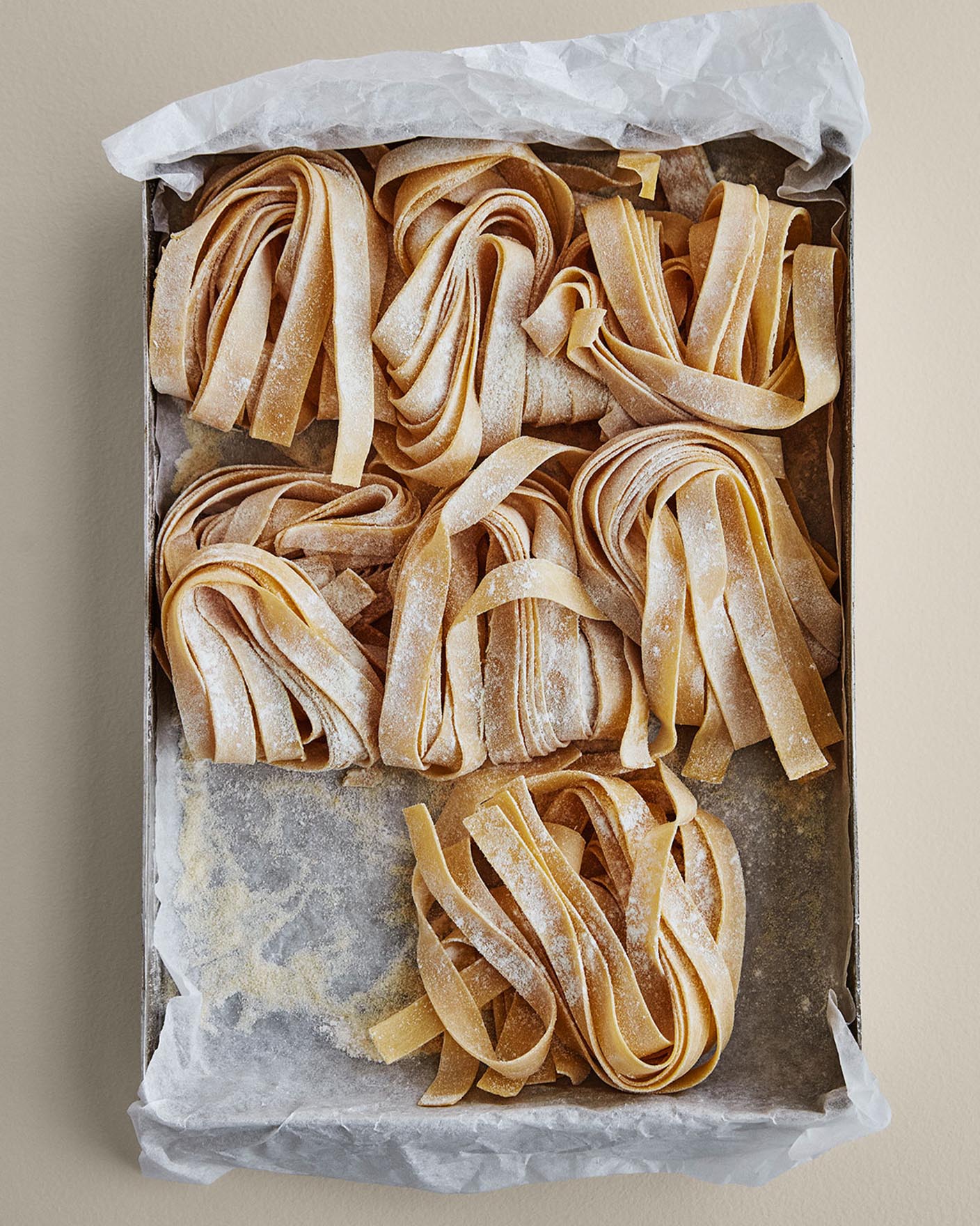 Fersk pasta ligger i et brett på en varm beige bakgrunn malt med Jotuns 10678 Space.