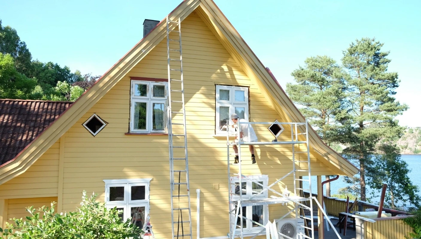 Mann males gult hus