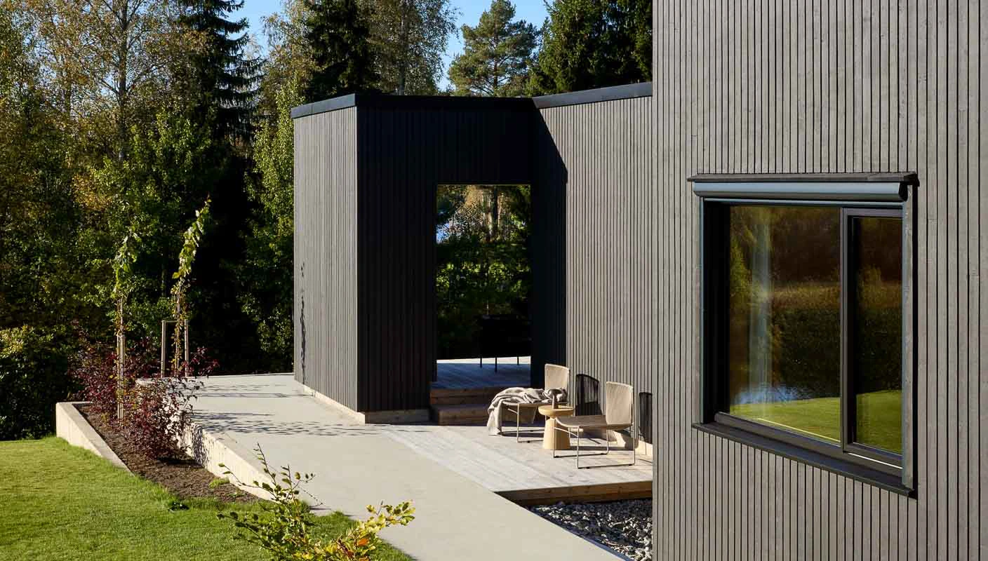 Moderne hus med matte, sorte vegger malt i JOTUN 9938 Dempet Sort med DRYGOLIN Nordic Extreme Supermatt.