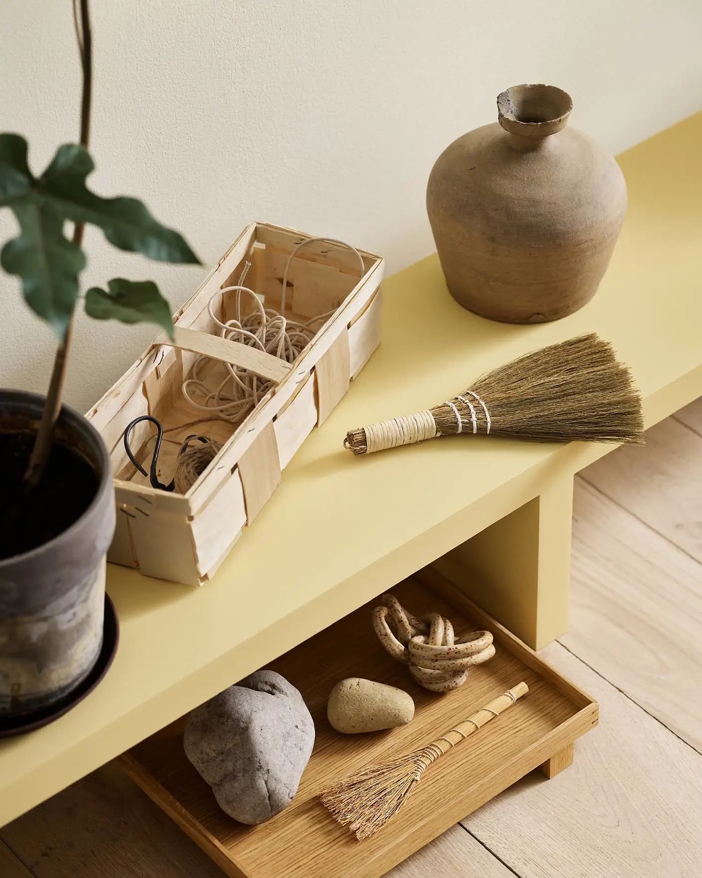 A yellow bench in the Jotun colour 1965 Ginger Tea against a golden, white wall painted in 1625 Soul.