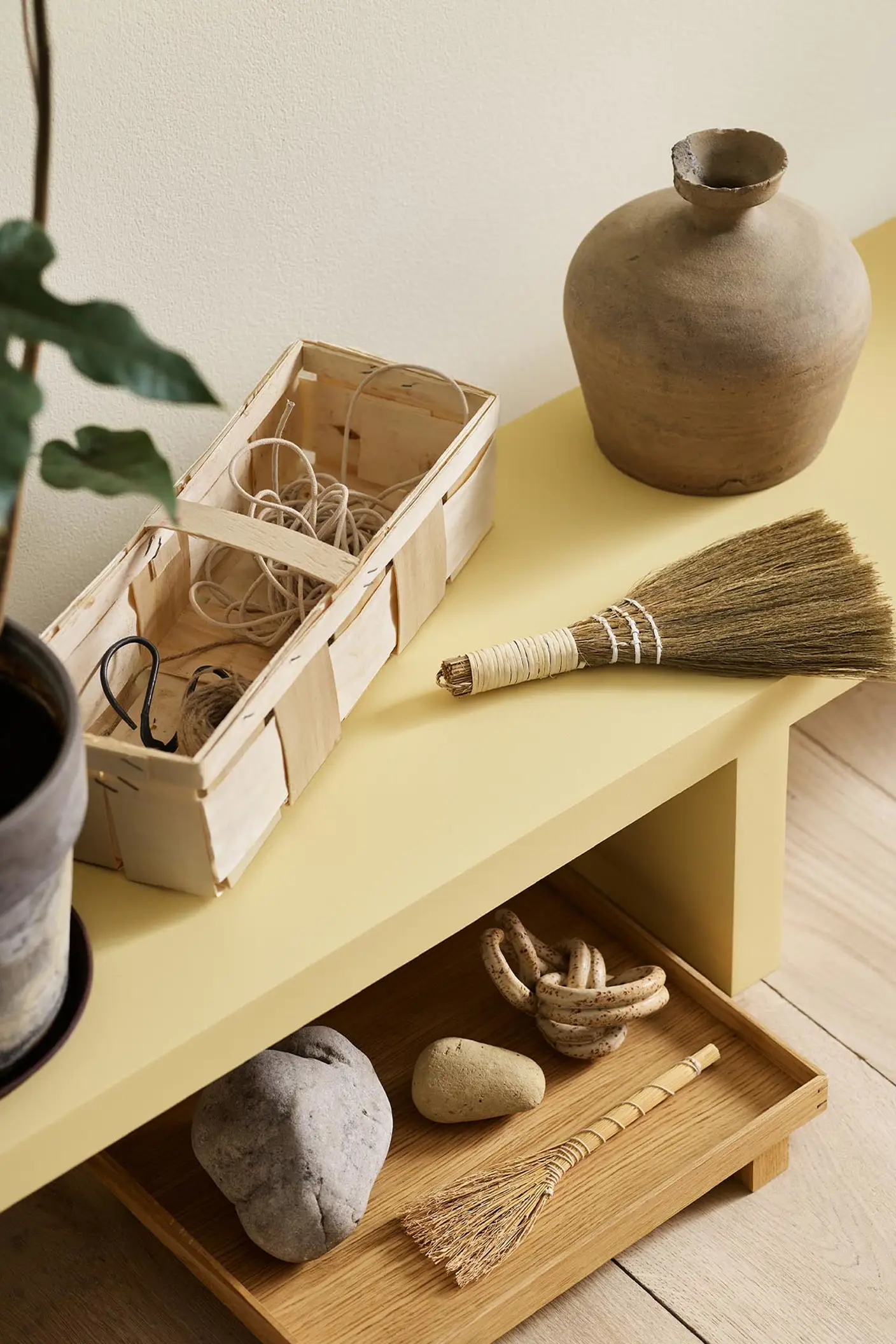 A yellow bench in the Jotun colour 1965 Ginger Tea against a golden, white wall painted in 1625 Soul.