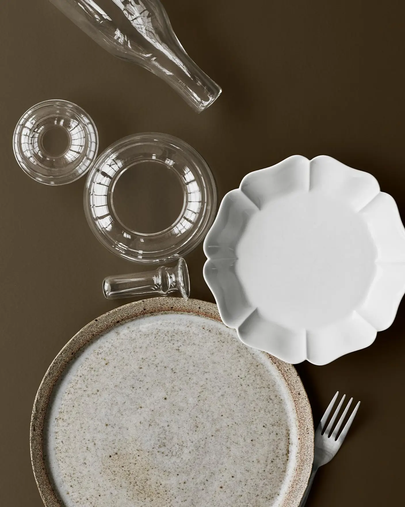 Servise i keramikk og glass på en gyllenbrun bakgrunn malt med 10385 Belgian Brown fra Jotun.