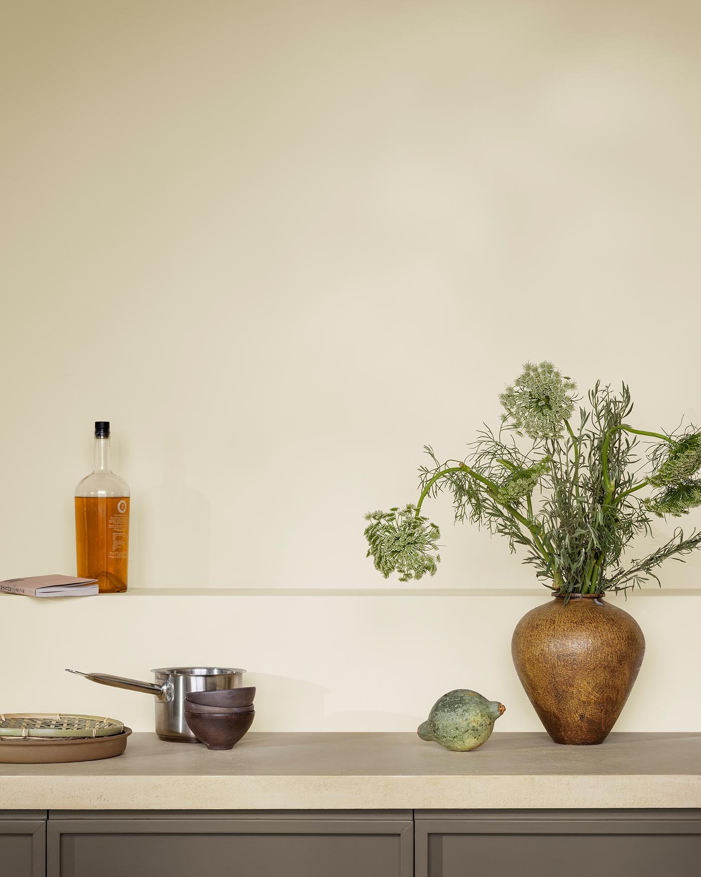 This kitchen feels airy and grounded with its golden beige walls painted by Jotun 1276 Soft and golden brown cabinets in the colour 11012 Rustic Brown from Jotun.