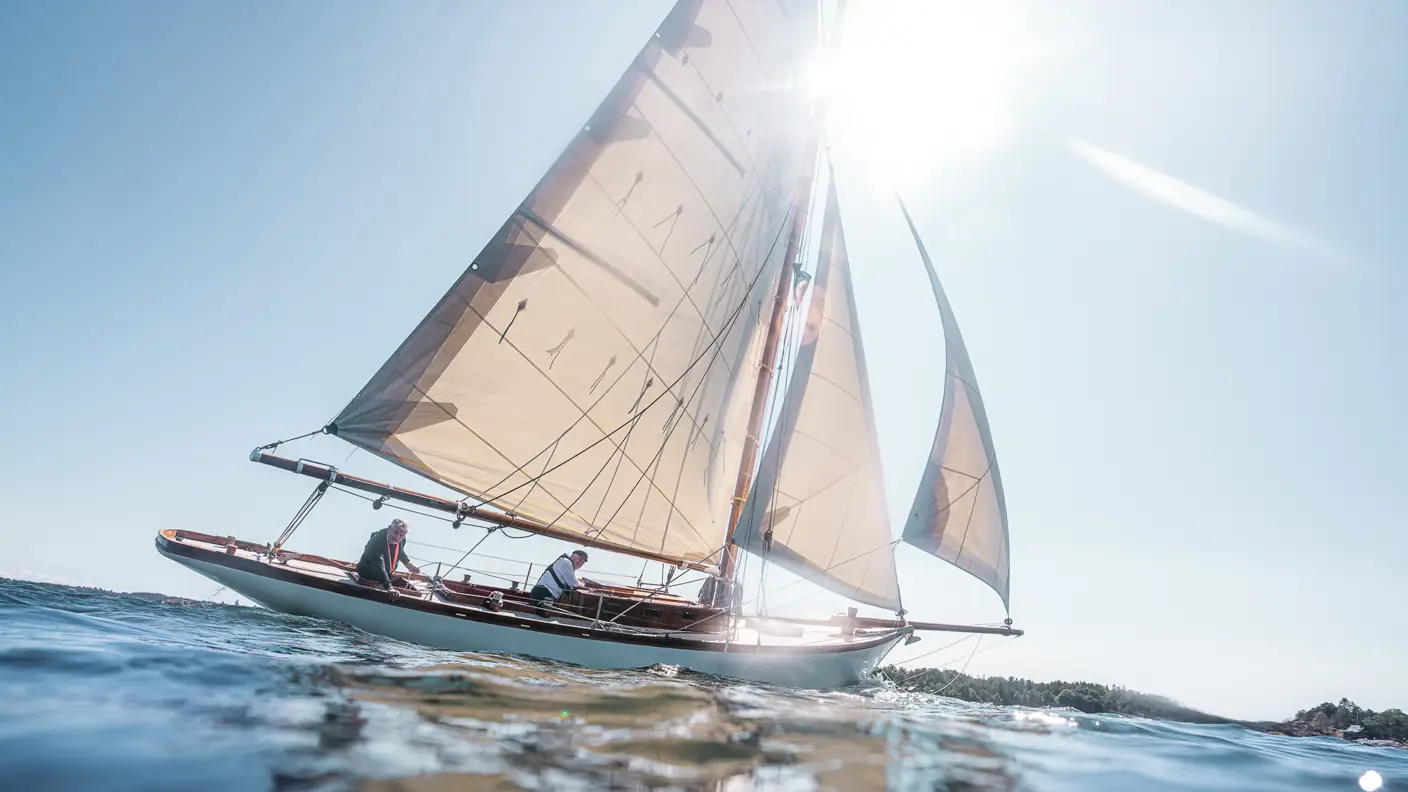 Seilbåt på blank sjø i solskinn