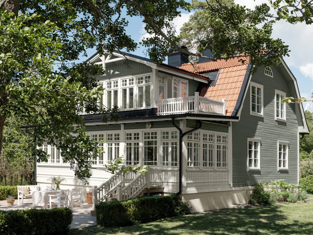 Grönt hus med vita detaljer målat med Jotun DEMIDEKK