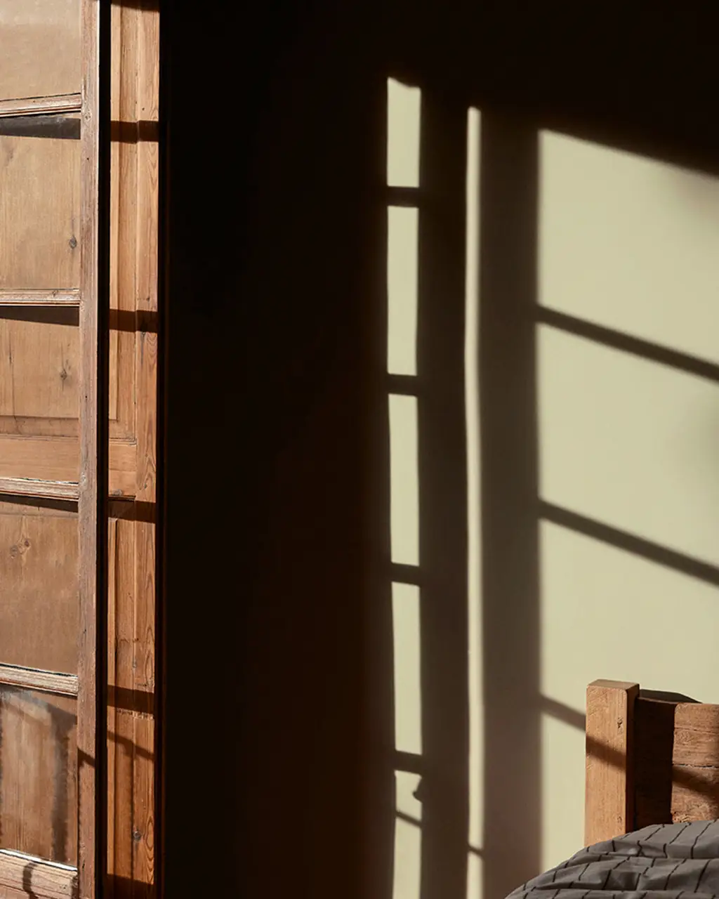 A view of a mountain landscape through a bedroom window, featuring Jotun 8753 Yellow Memories.