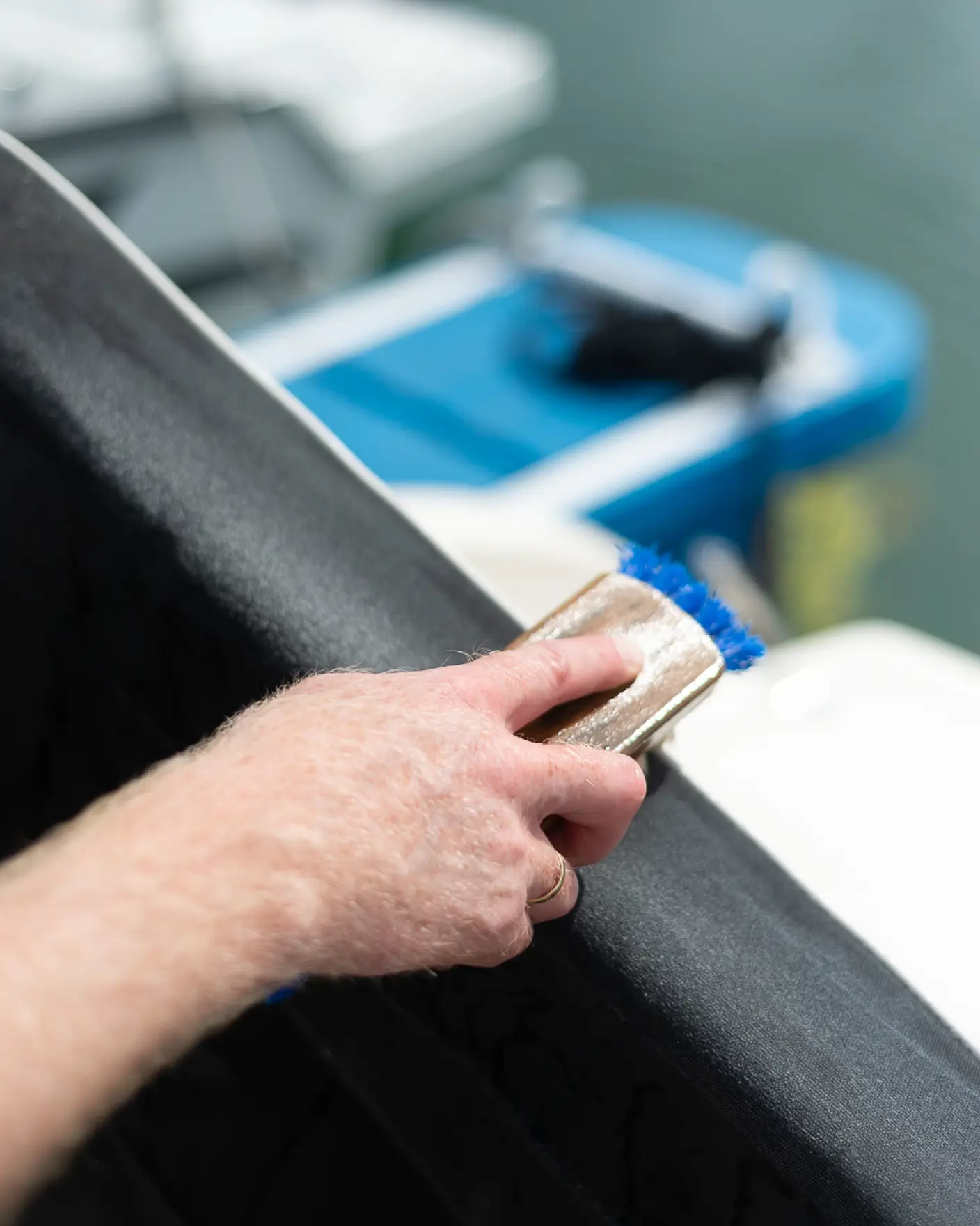 Vasking av båtpute med skrubbebørste.