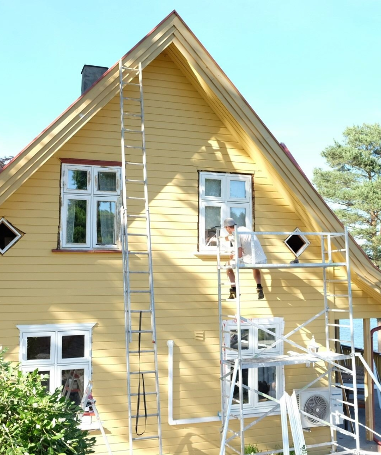 Et eldre, slitt hus males i Jotun Staverngul