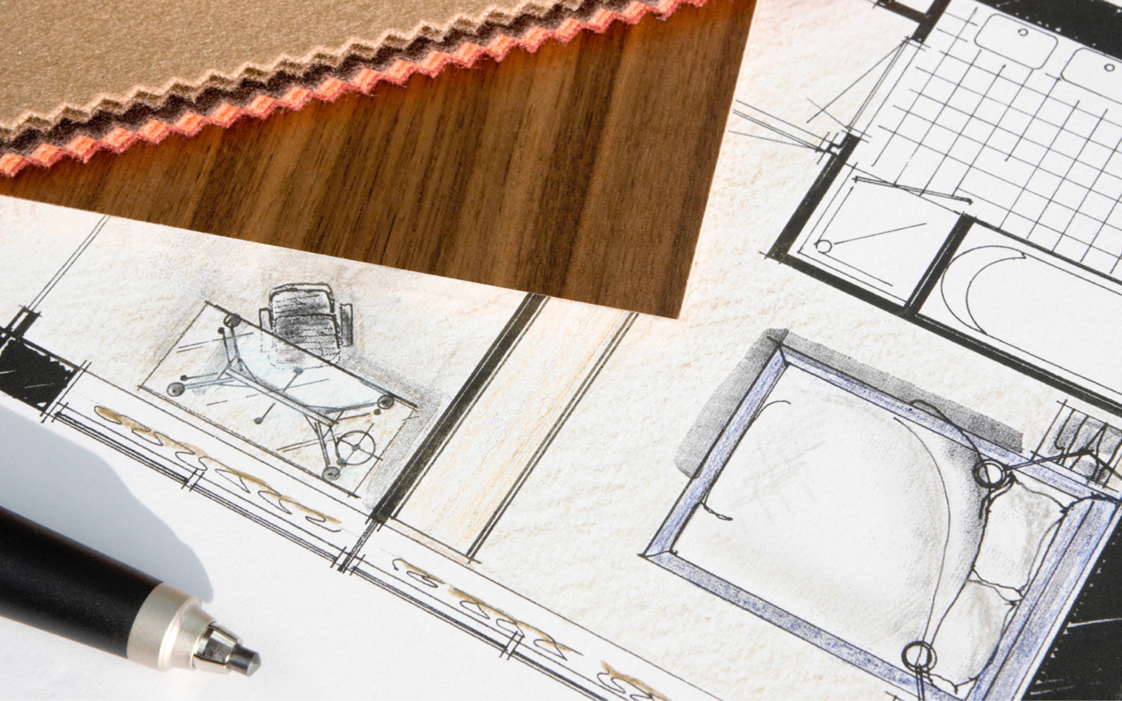 Sketches of a room on a piece of paper on a wooden table.