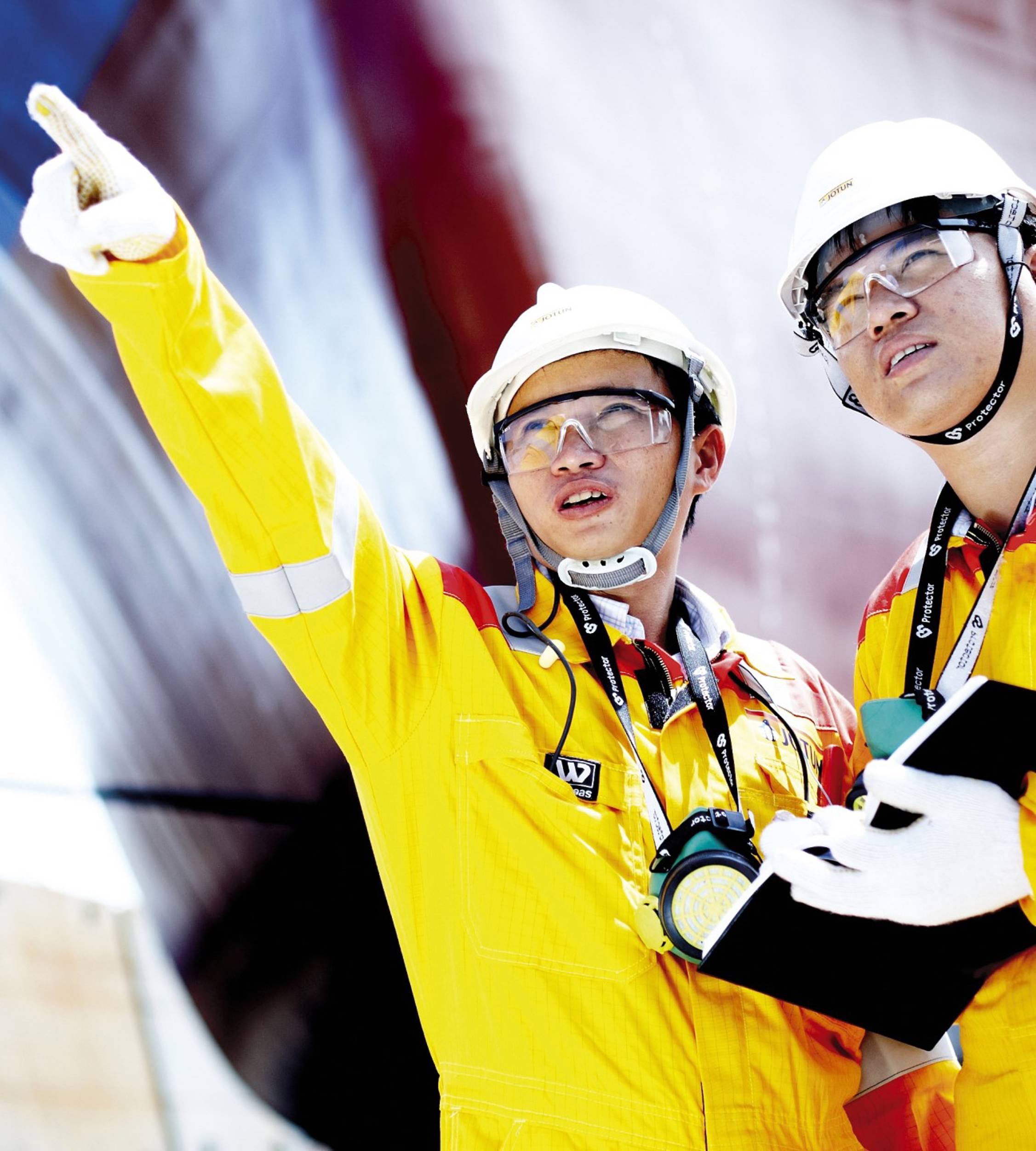 Two engineers, yellow overalls and hard hats