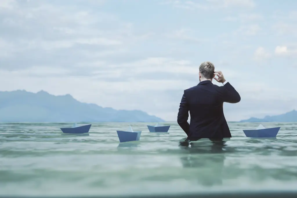 Man wading among paper ships