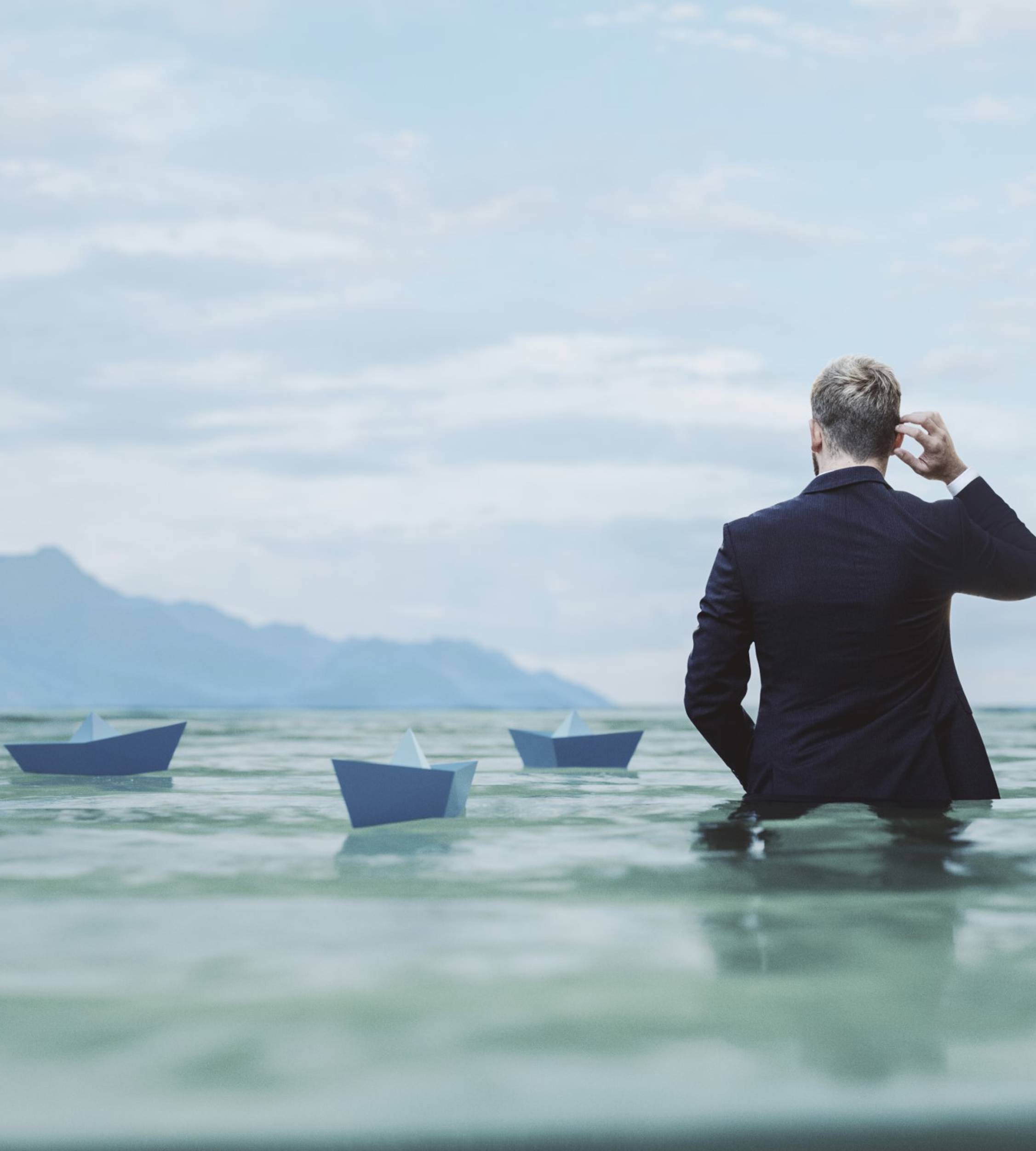 Man wading among paper ships