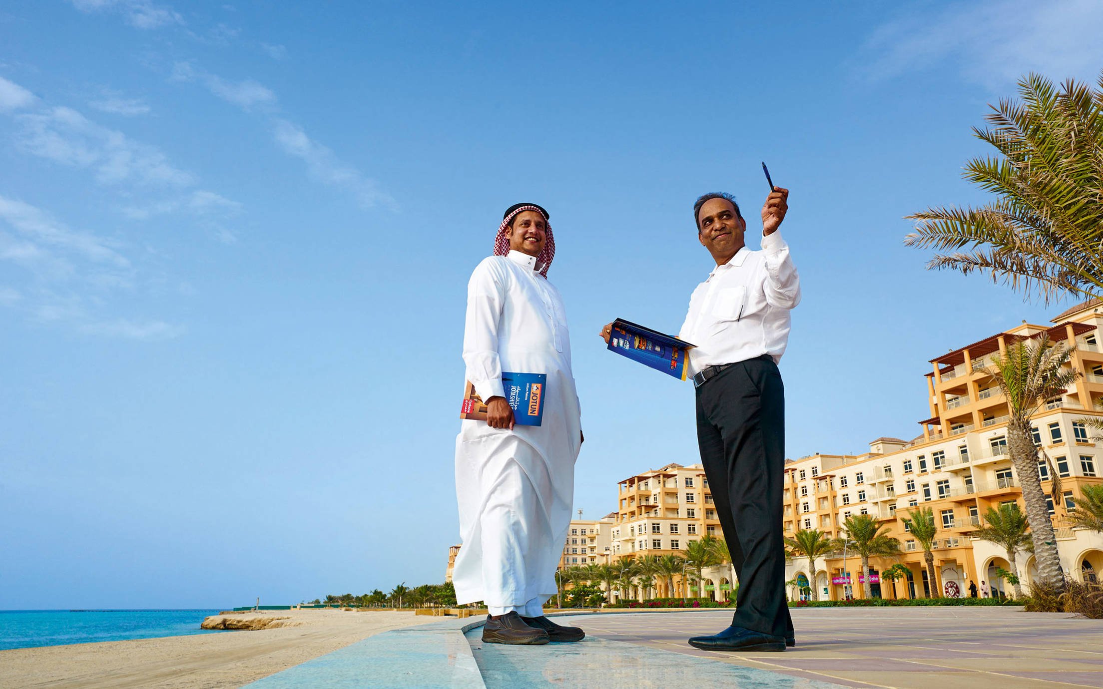 Two salesmen from the Middle East having a chat and smiling