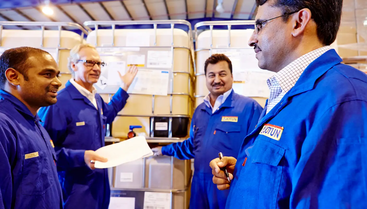Four people attending a safety walk for "safe storage of goods" at Jotun. Here, safety walks are conducted regularly.