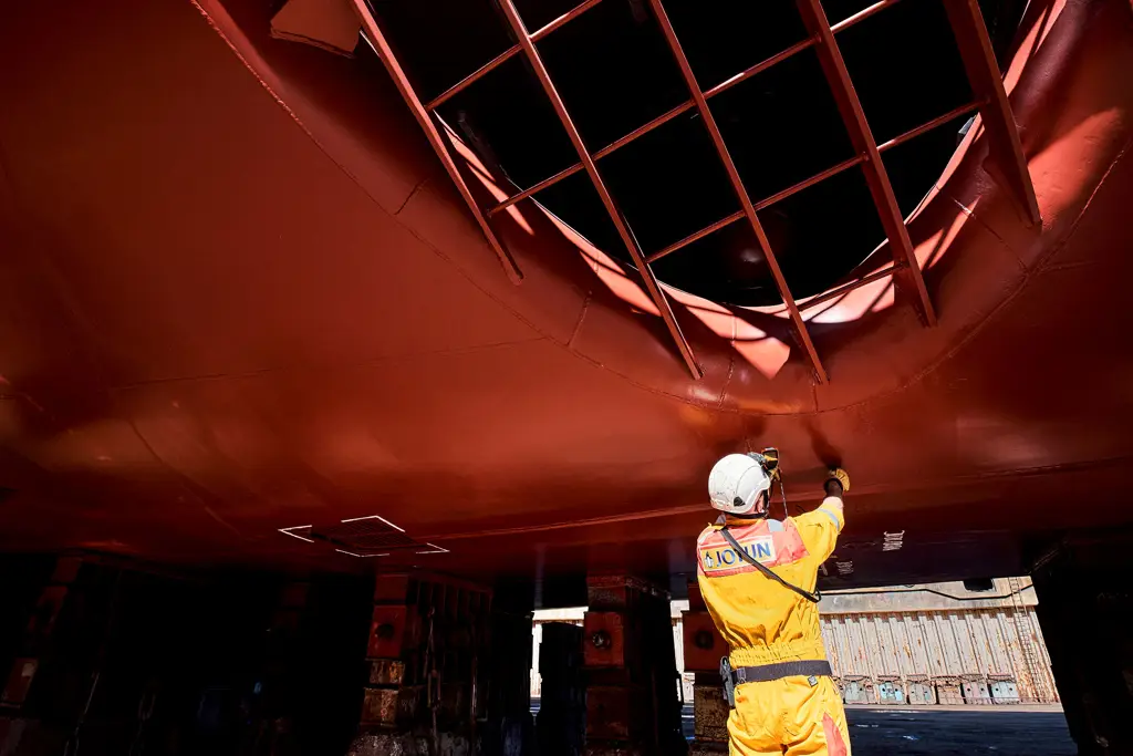 A technical inspector measuring thickness of the coating on a ship hull