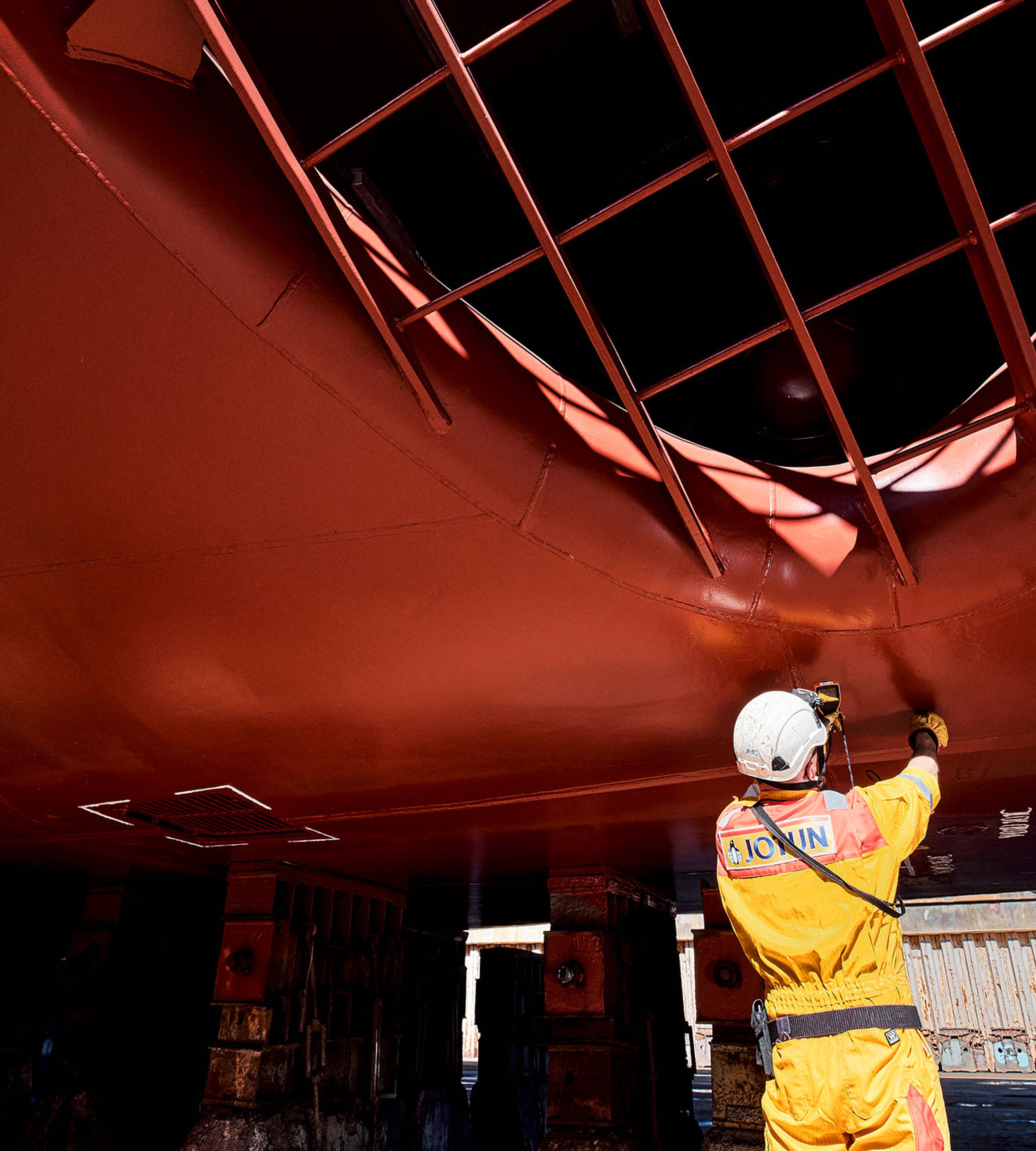 A technical inspector measuring thickness of the coating on a ship hull