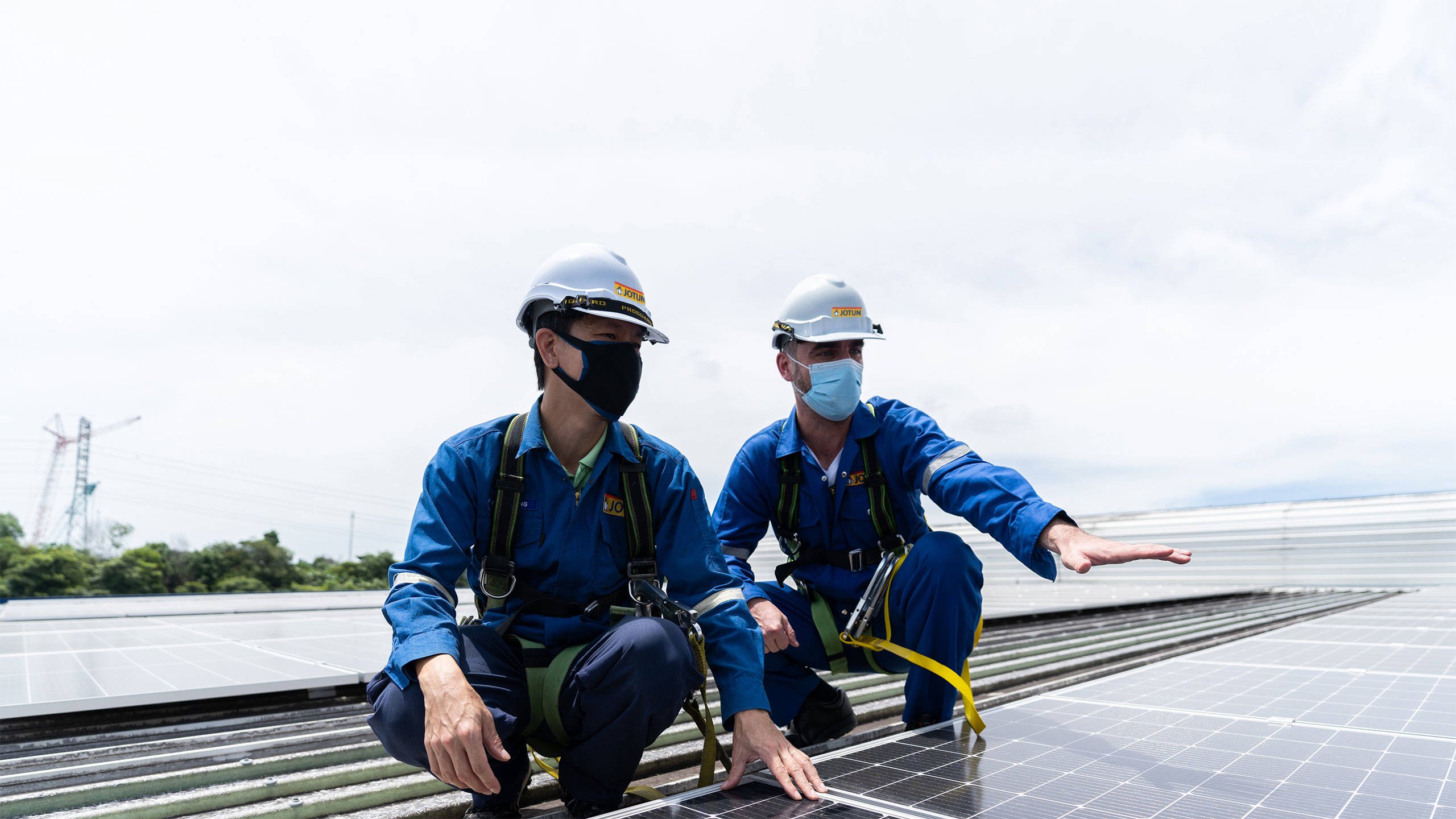 Two men inspecting the solar panels on the roof Jotun's factory i Nilai, Malaysia