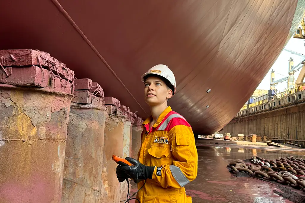Nilay Yilmaz standing in the dock looking up on a ship hull