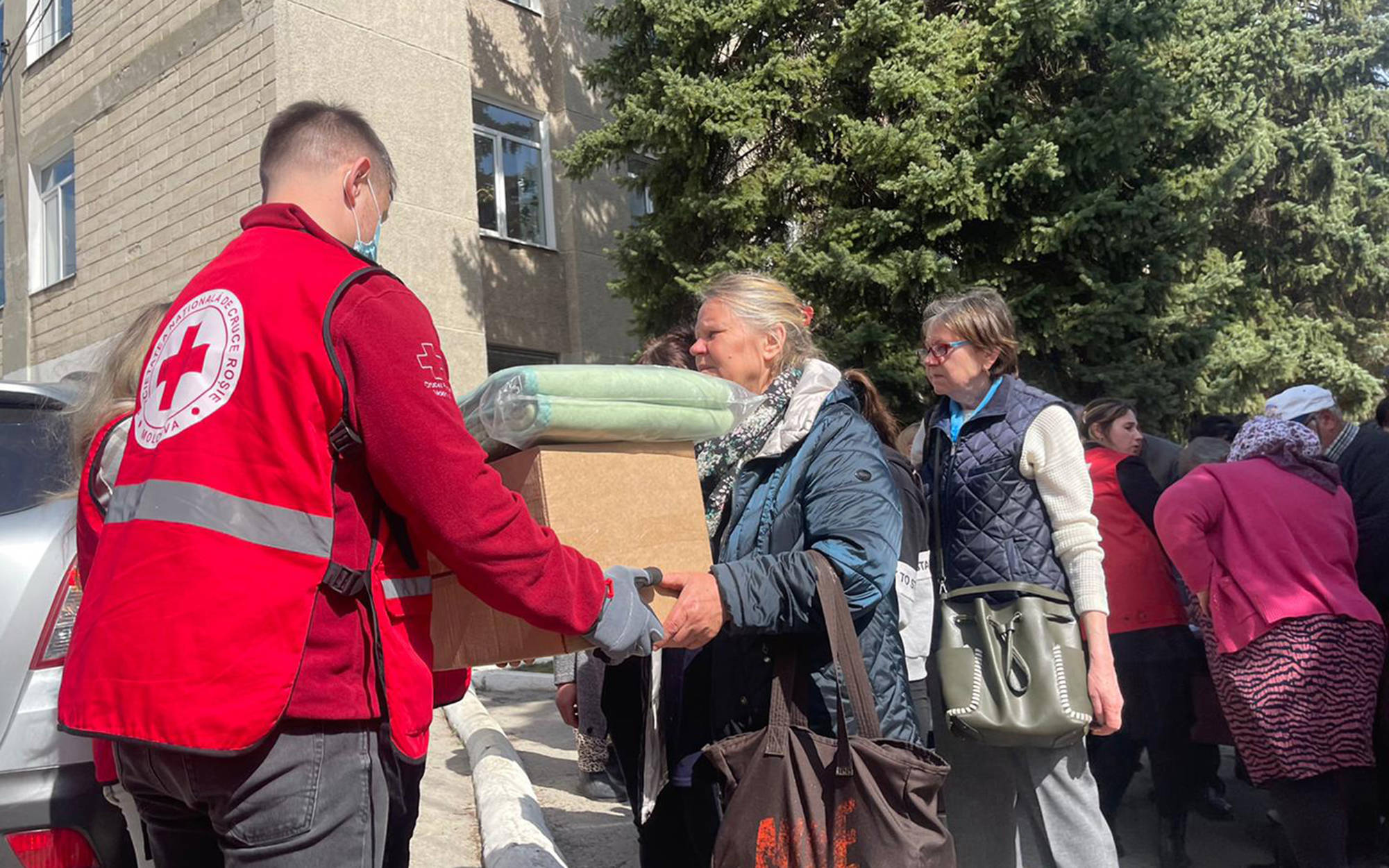 A woman receiving food and blankets from a Red Cross worker. Photo: Ville Palonen / Finnish Red Cross