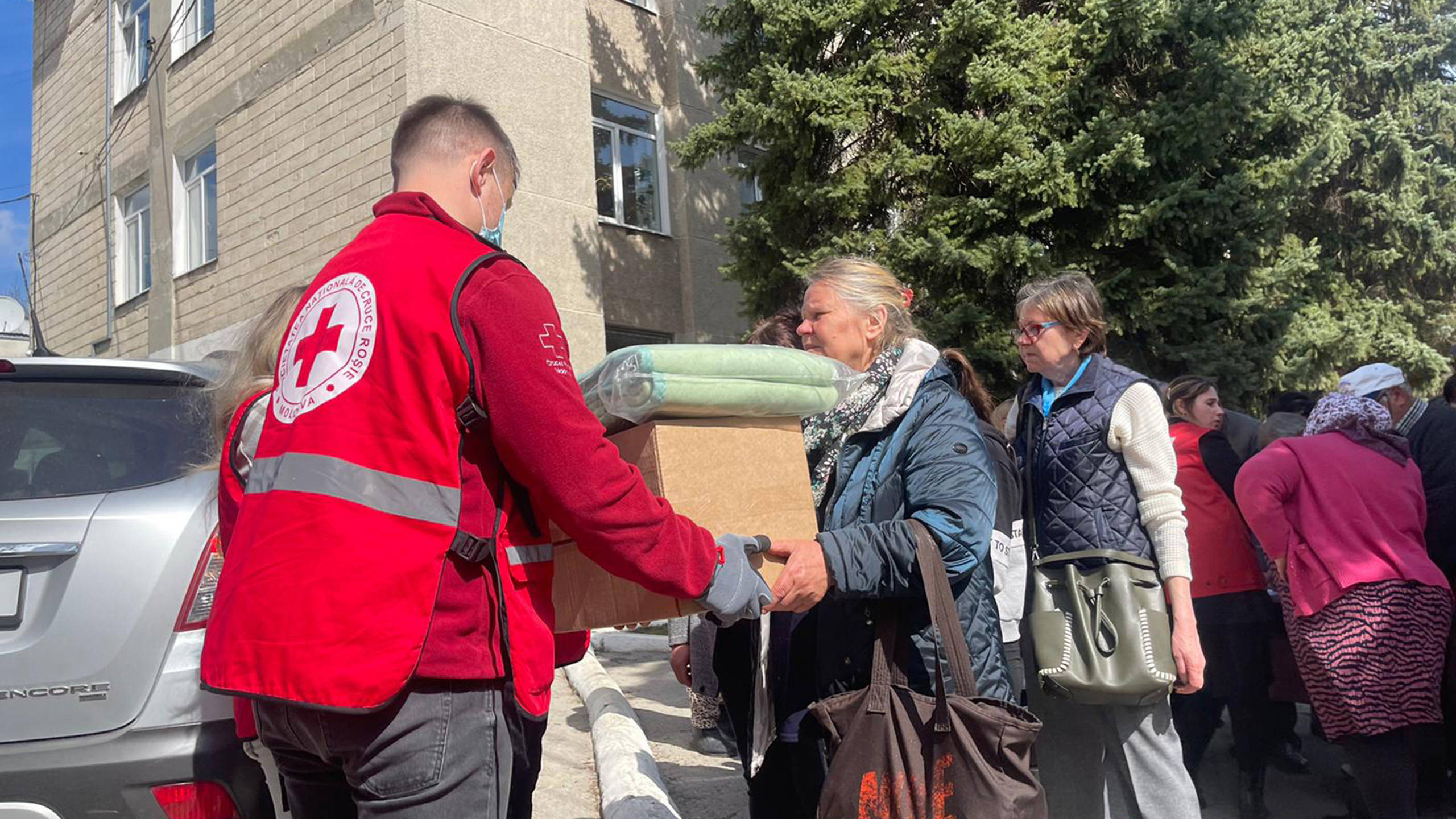 A woman receiving food and blankets from a Red Cross worker. Photo: Ville Palonen / Finnish Red Cross