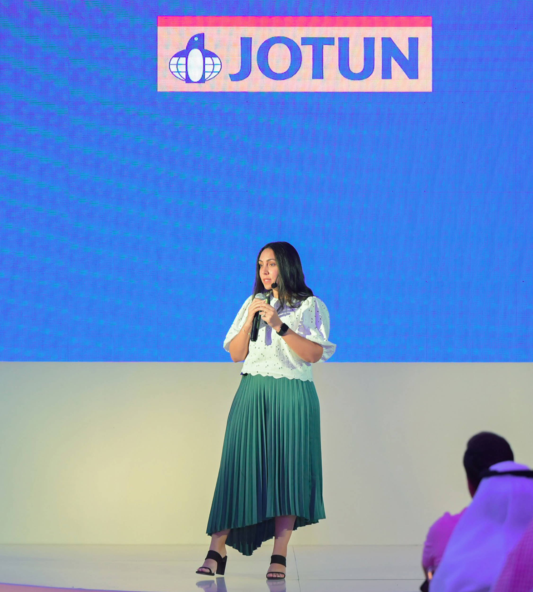 Yasmine Eladly on stage with a microphone