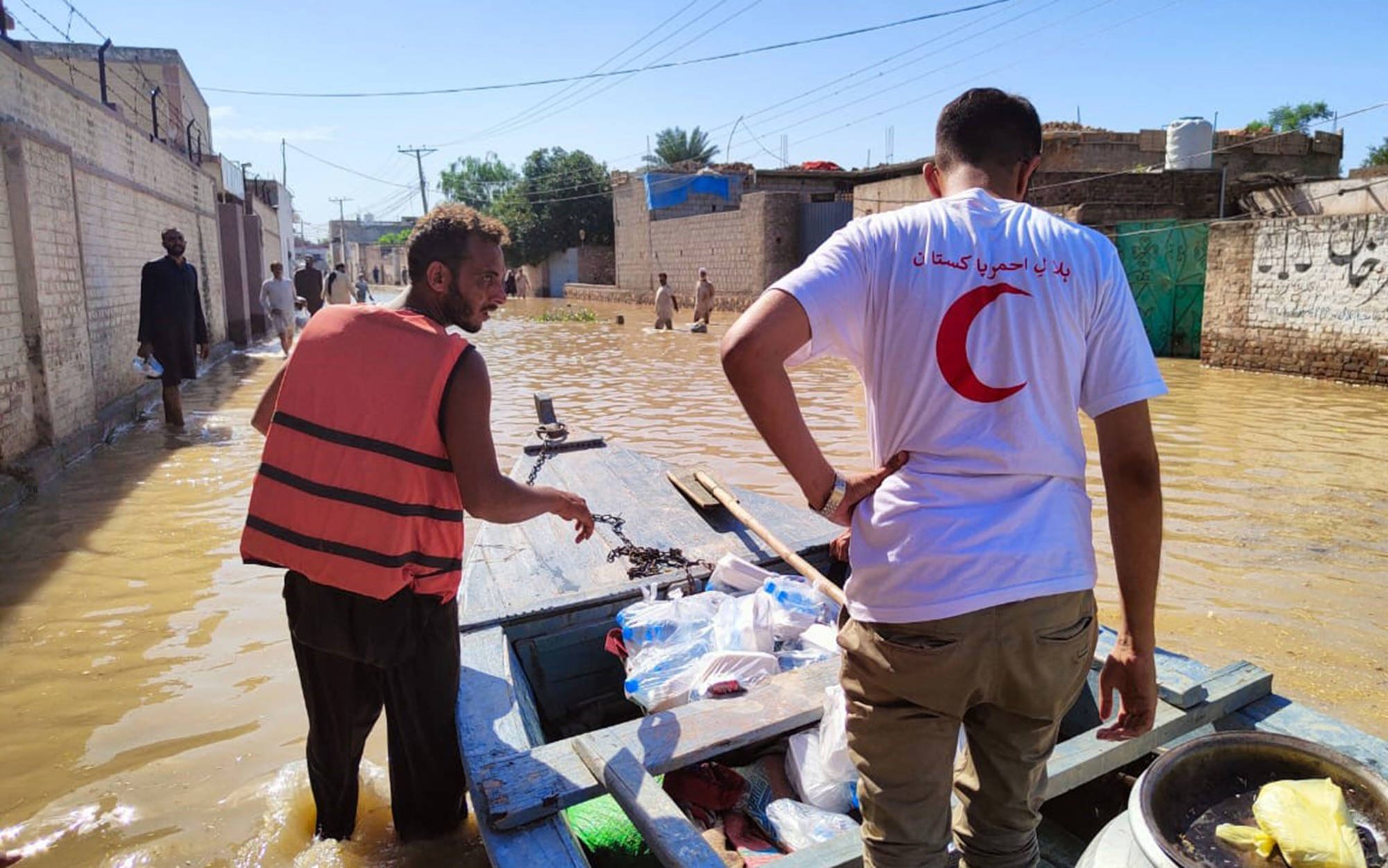 Two men in a flooded street in Pakistan. Photo: Red Cross/Red Crescent