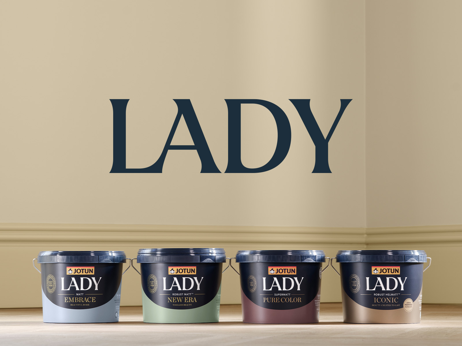 Jotun LADY paint cans displayed against a beige wall with the word “LADY” above them