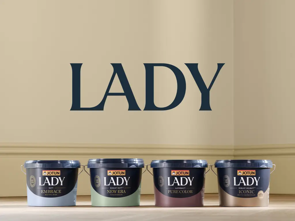 Jotun LADY paint cans displayed against a beige wall with the word “LADY” above them